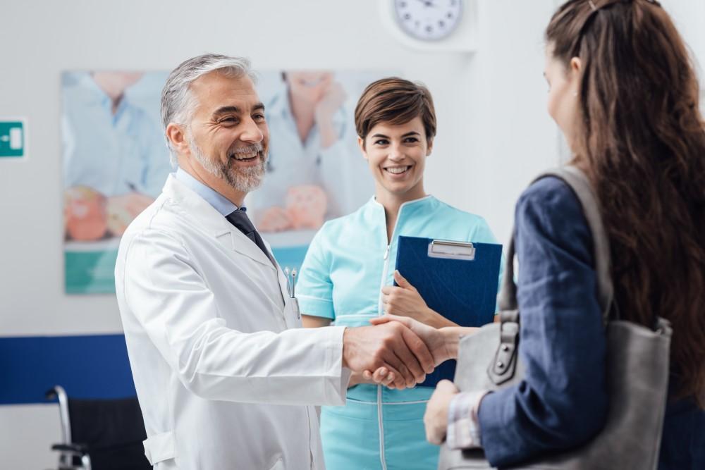 Foot doctor with smiling woman getting shockwave therapy